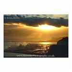 The sun breaks through a gap in the clouds and shines down on Dover docks. Taken from the famous White Cliffs of Dover, Kent.